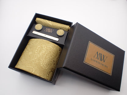 A premium black gift box containing a champagne gold paisley floral jacquard patterned men's necktie, matching pocket square, cufflinks, and a silver tie clip.