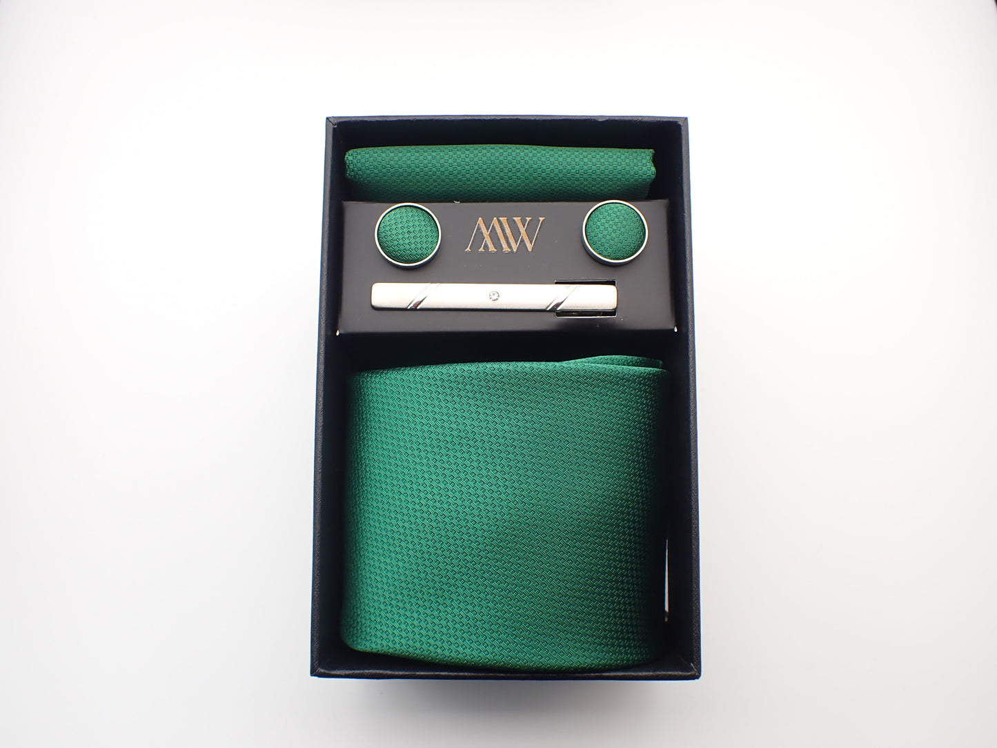 A black presentation box containing a rich emerald green micro-woven men's necktie, matching pocket square, round cufflinks, and a silver tie clip.