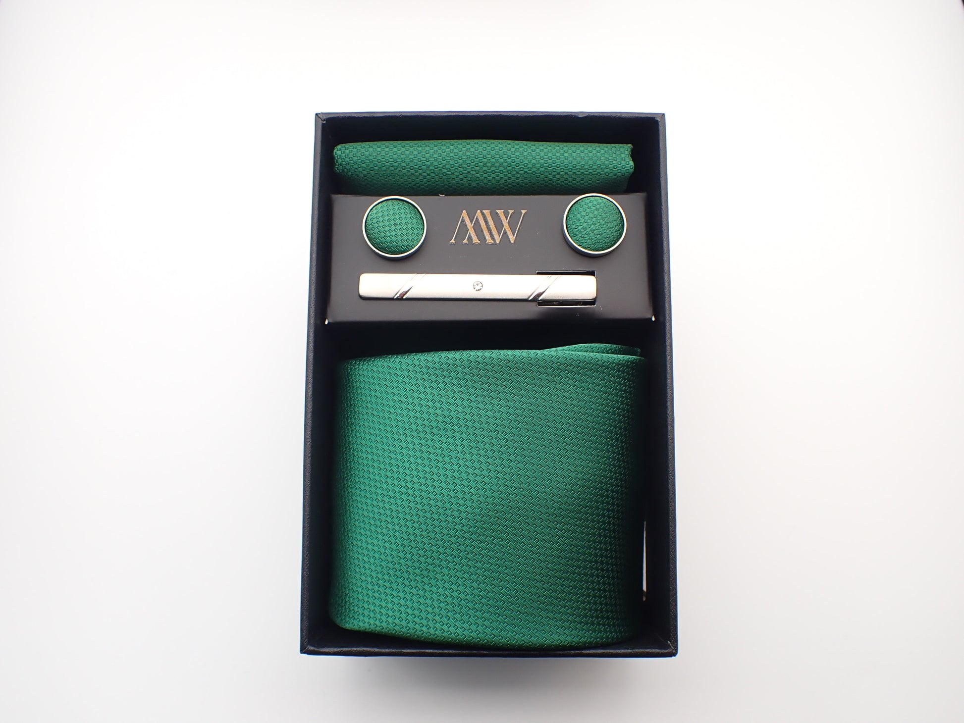 A black presentation box containing a rich emerald green micro-woven men's necktie, matching pocket square, round cufflinks, and a silver tie clip.