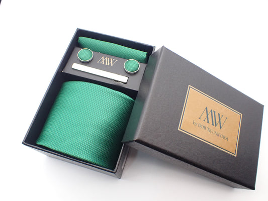 A black presentation box containing a rich emerald green micro-woven men's necktie, matching pocket square, round cufflinks, and a silver tie clip.