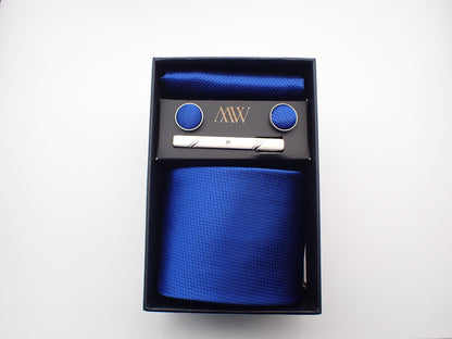 A classic royal blue micro-woven men's necktie, matching pocket square, cufflinks, and a silver tie clip neatly packed in a black gift box.