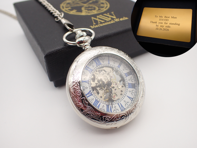 Silver hand-wind mechanical skeleton pocket watch featuring blue Roman numerals and intricate floral engraving, perfect for groomsmen gifts.