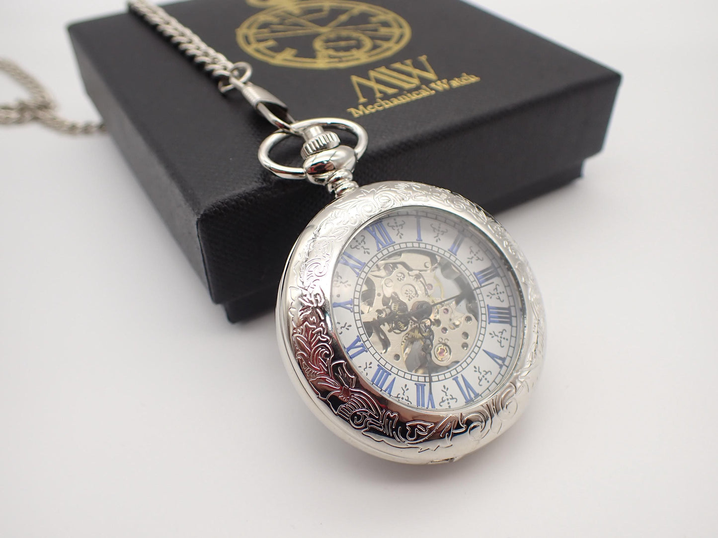 Silver hand-wind mechanical skeleton pocket watch featuring blue Roman numerals and intricate floral engraving, perfect for groomsmen gifts.